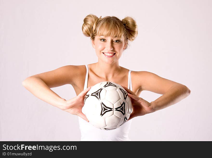 Young blonde in sportswear with a football