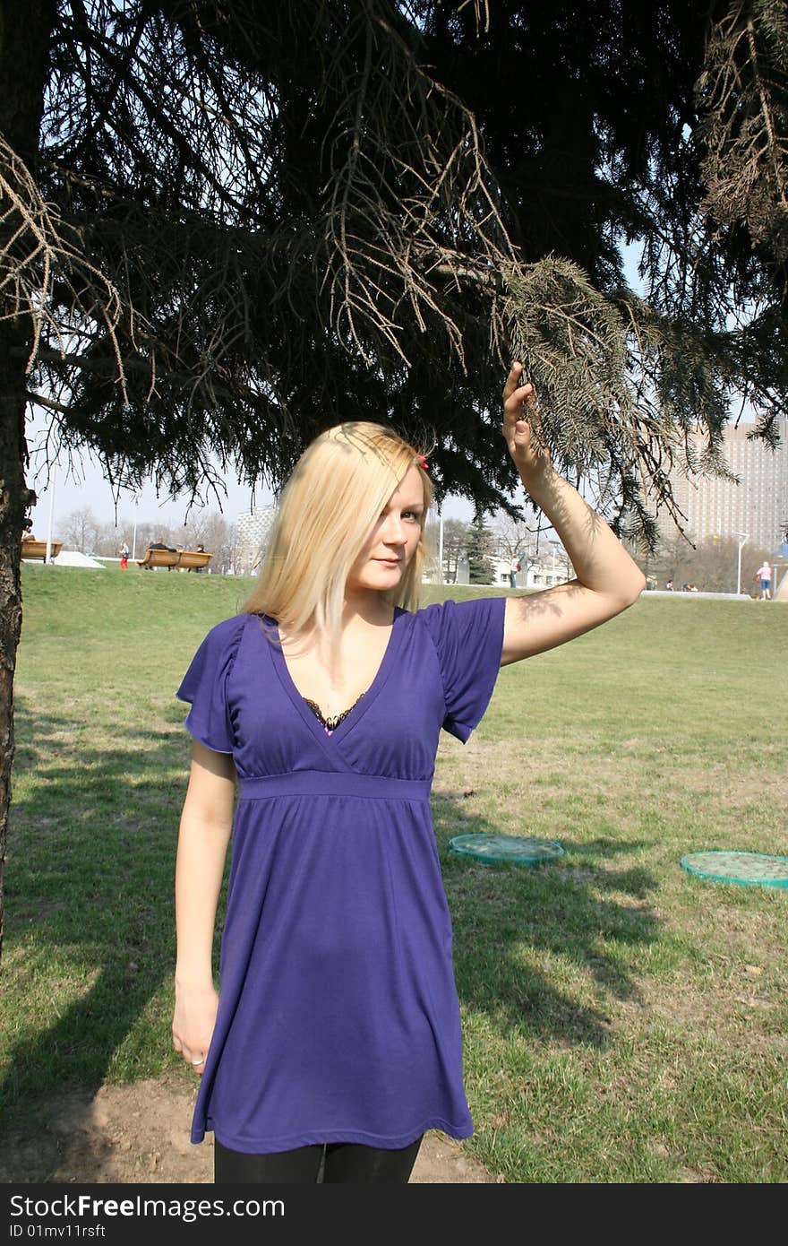 Girl standing under a fir-tree outdoor