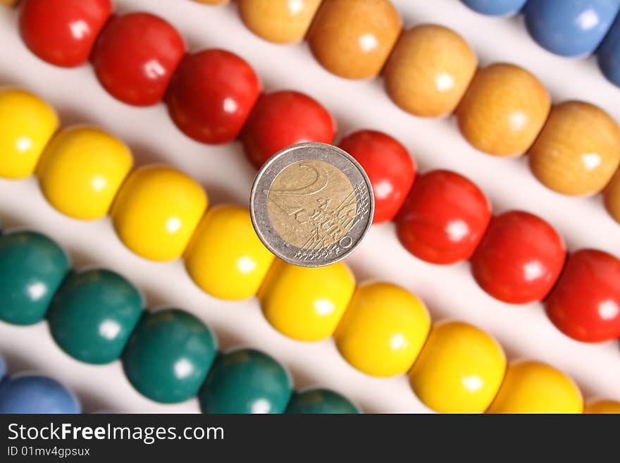 Two Euro-coin with unsharp background of an abacus. Two Euro-coin with unsharp background of an abacus