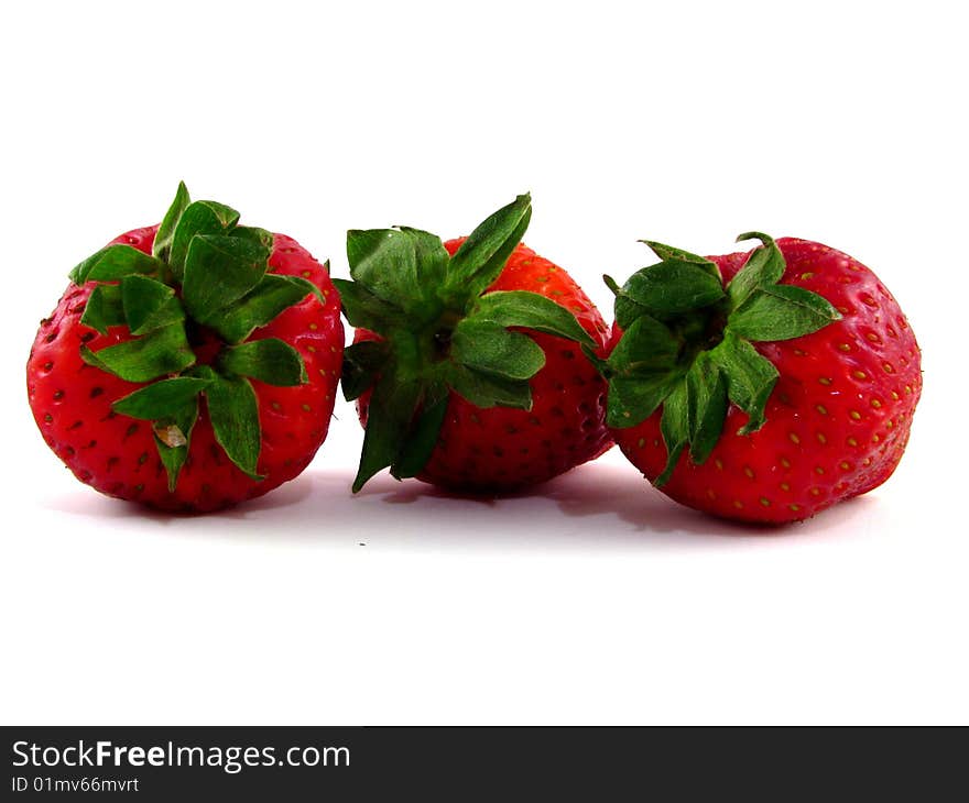 A row of three strawberries on a white background