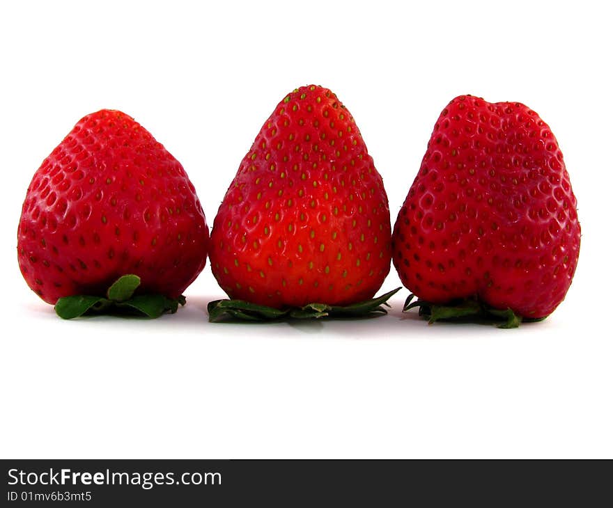 A row of three strawberries on a white background