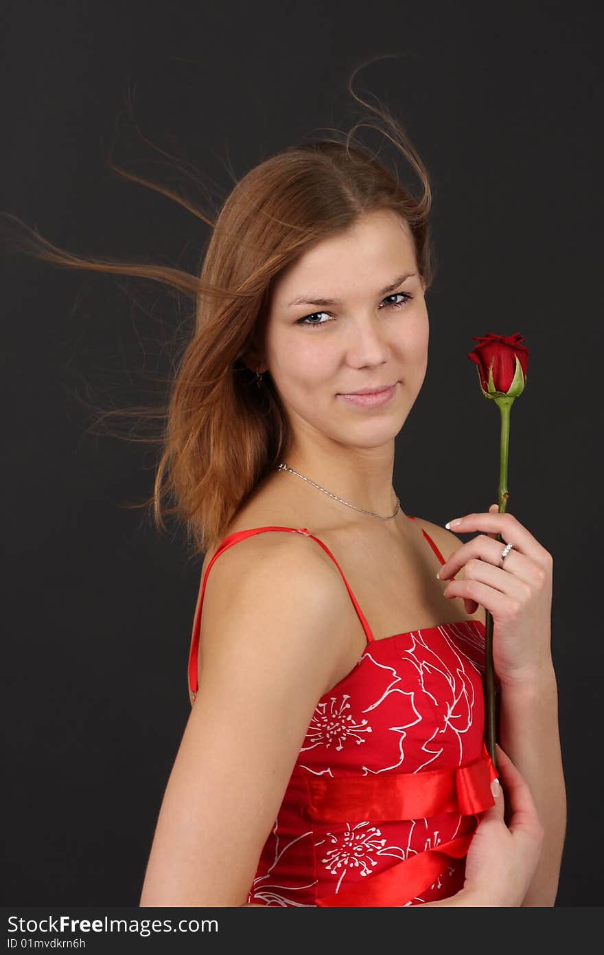 Portrait of young woman in red-white outfit with red rose. Portrait of young woman in red-white outfit with red rose