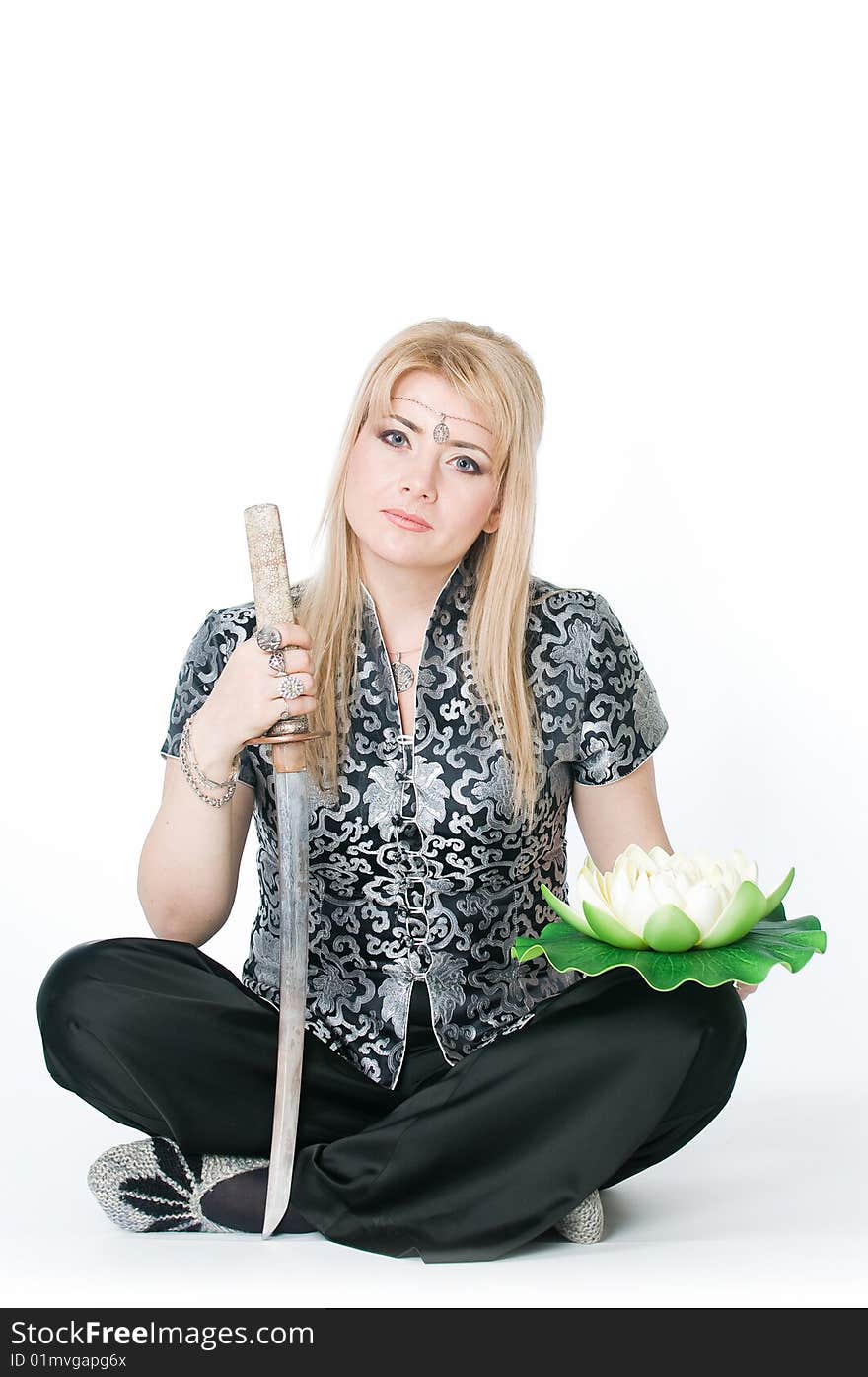 Woman sitting in lotus pose with katana, isolated on white background