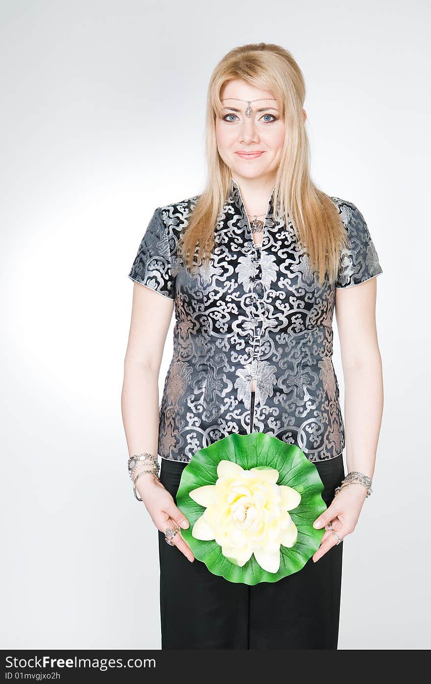 Attractive woman with lotus flower, studio shot