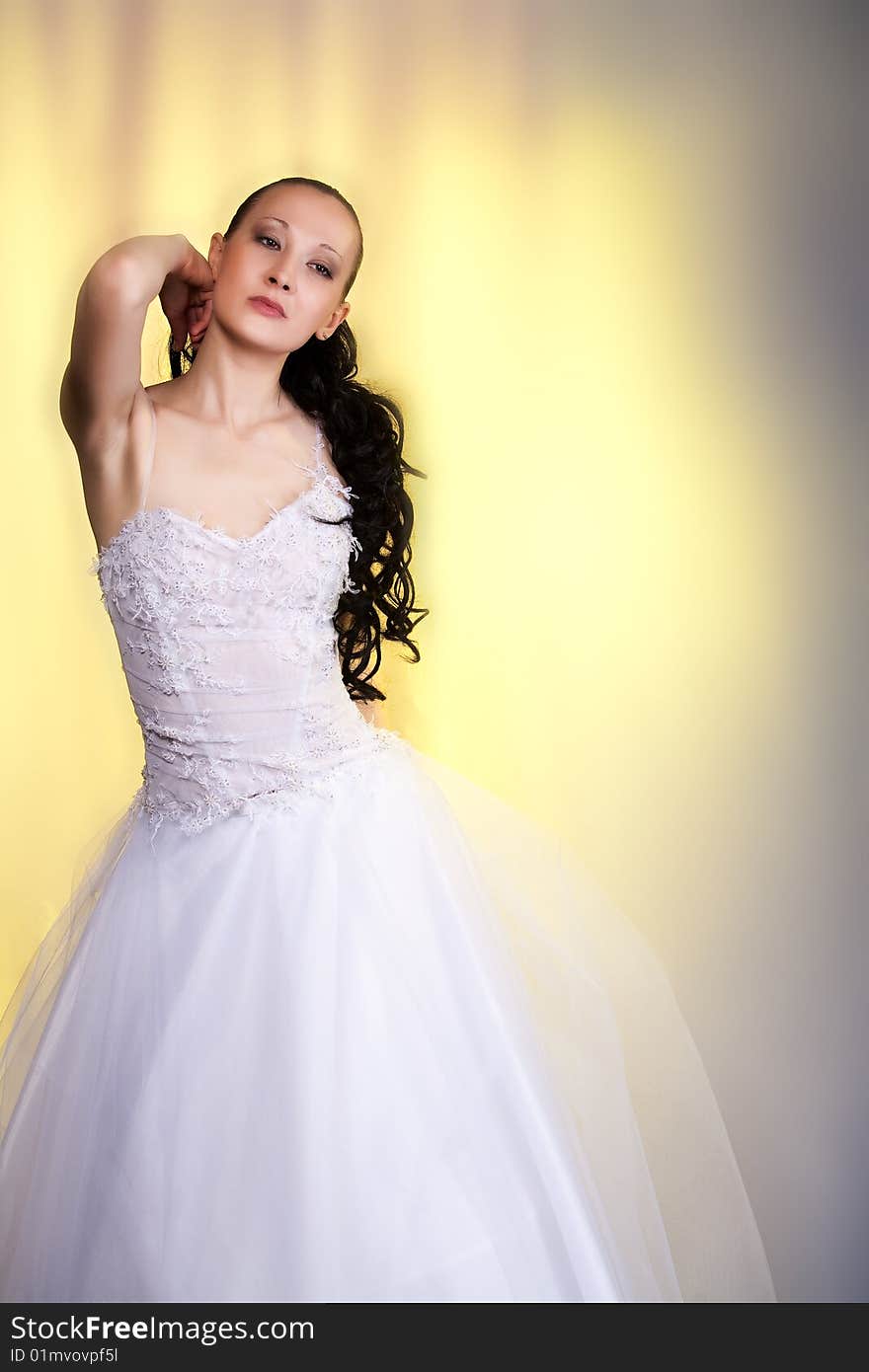 Girl in white wedding dress standing with hands lifted up