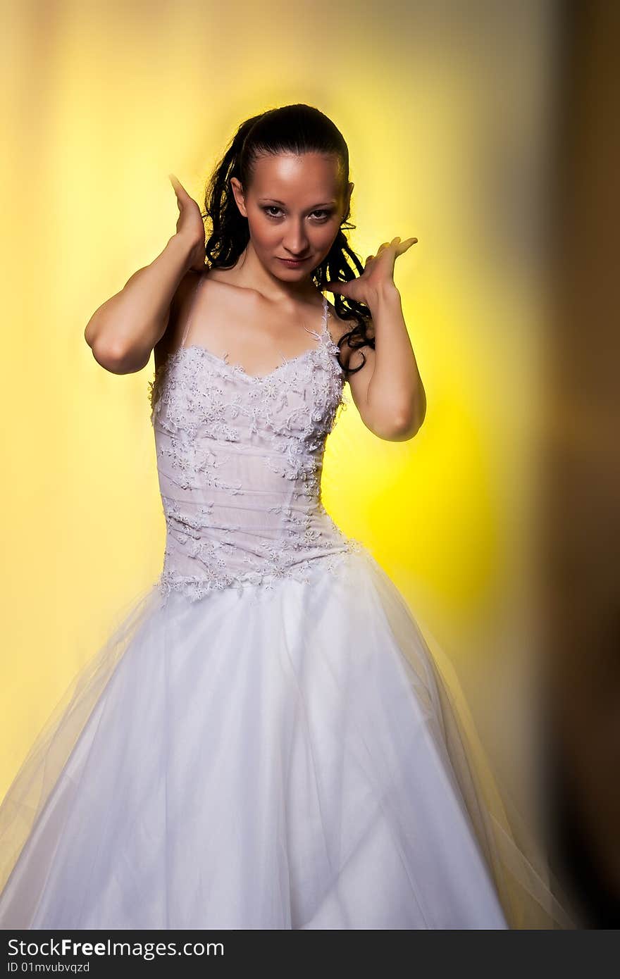 Girl in white wedding dress with hands lifted up