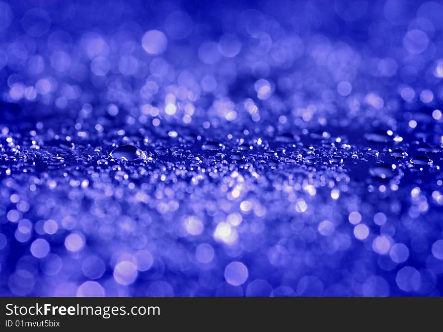 Closeup of fresh clean water drops on blue background