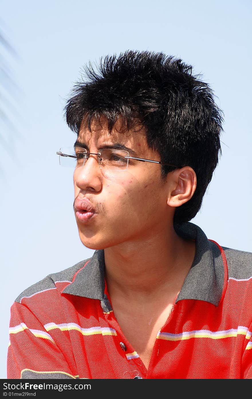 A funky young Indian teenager blowing the whistle in a happy mood. A funky young Indian teenager blowing the whistle in a happy mood.