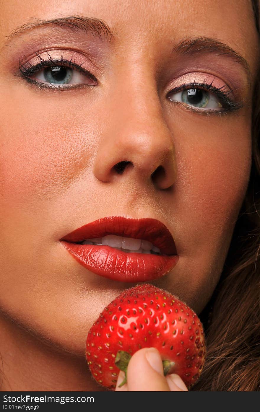 Young woman close up with strawberry focus on the face. Young woman close up with strawberry focus on the face