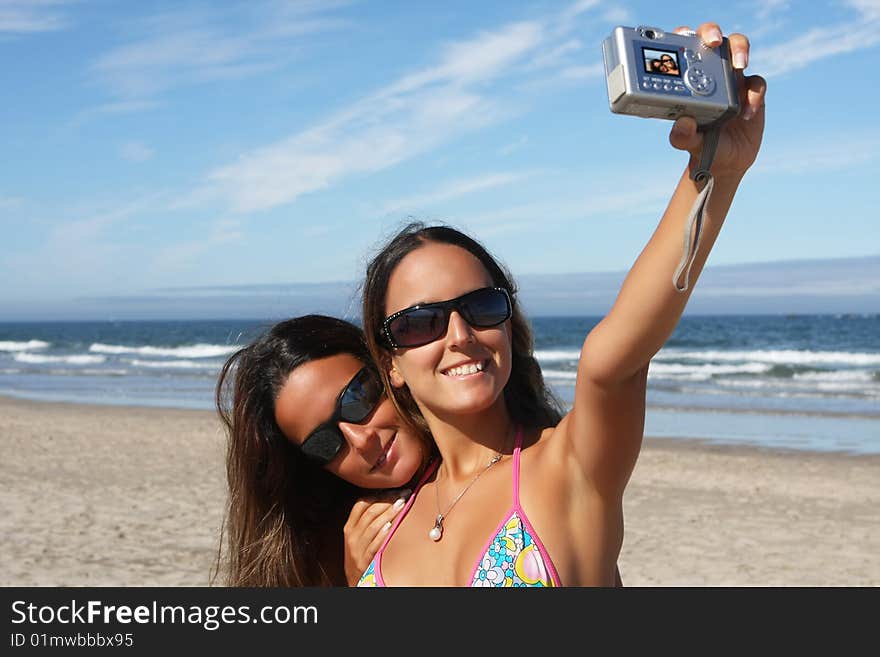 Twins taking a photo of themselves on the beach