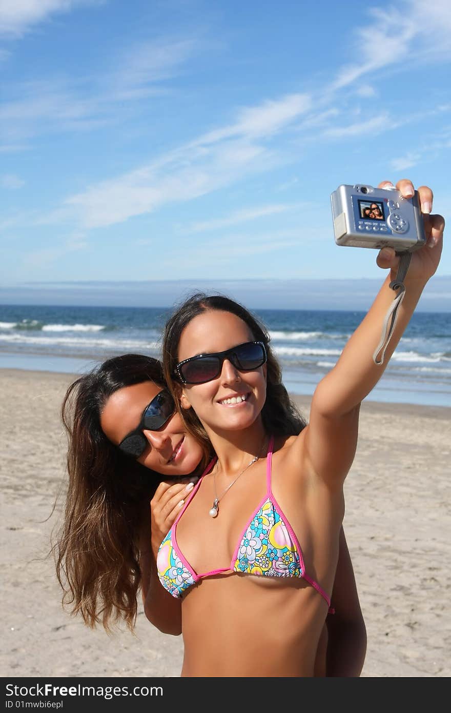 Twins taking a photo of themselves on the beach