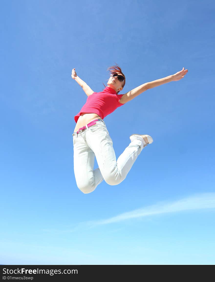 Happy jumping girl against blue sky. Happy jumping girl against blue sky