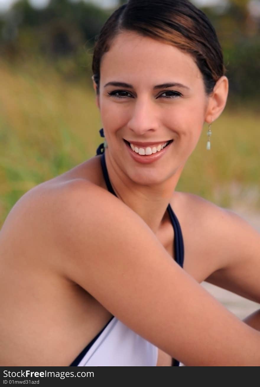 Young woman in white bathing suit sitting on beach. Young woman in white bathing suit sitting on beach