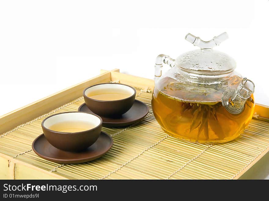 Tea serving in ceramic cups and glass teapot isolated on white. Tea serving in ceramic cups and glass teapot isolated on white