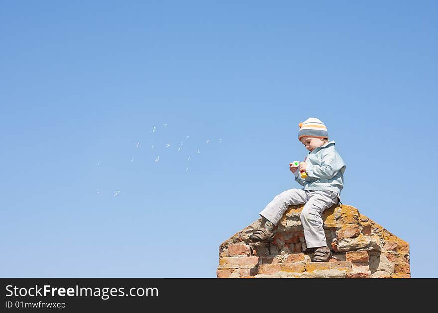 Boy blowing bubbles under the sky