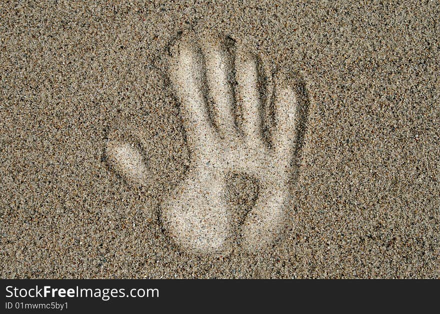 White hand on the sand