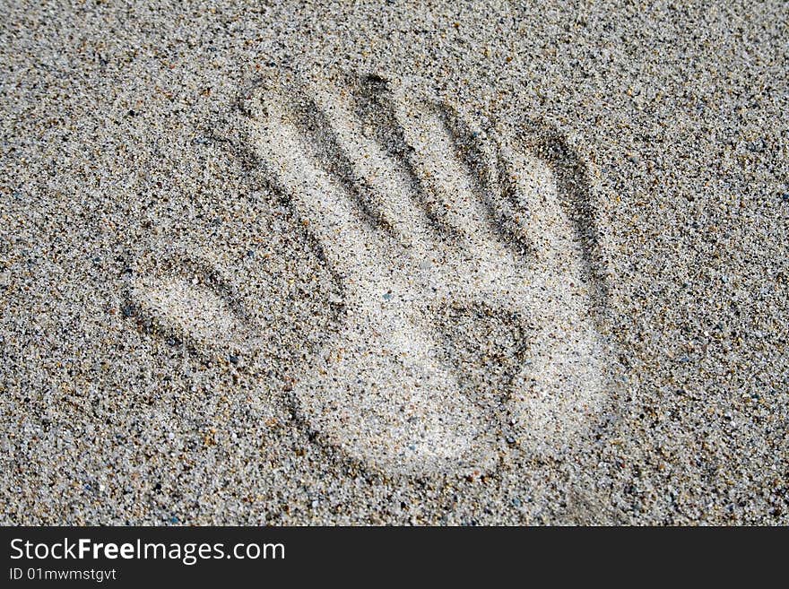 White hand on the sand