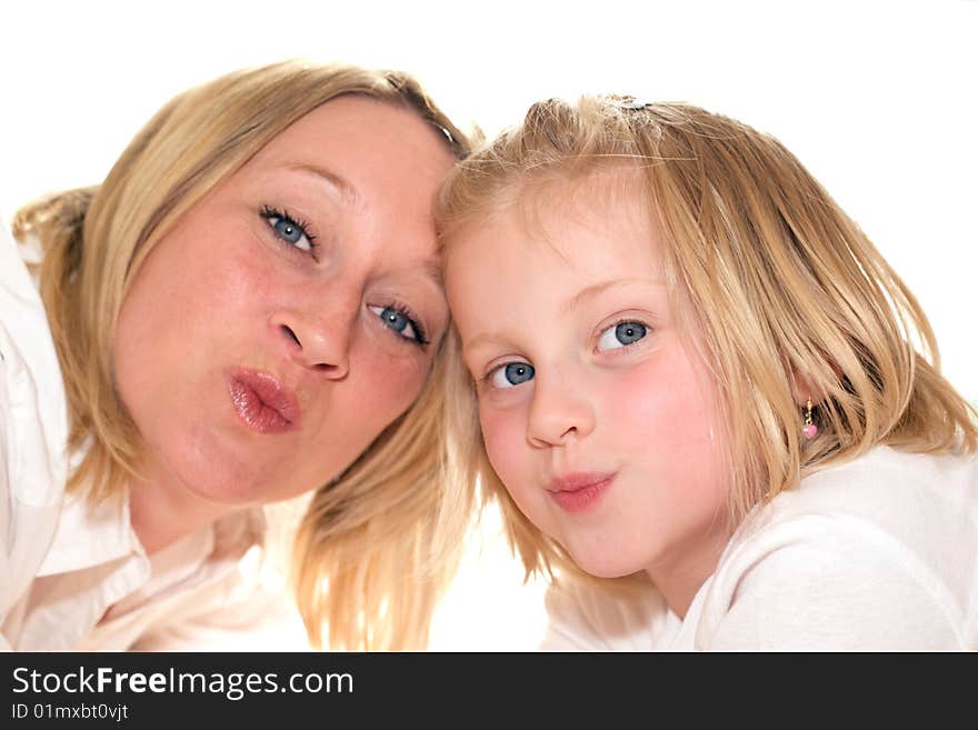 Mother and daughter giving kisses into camera