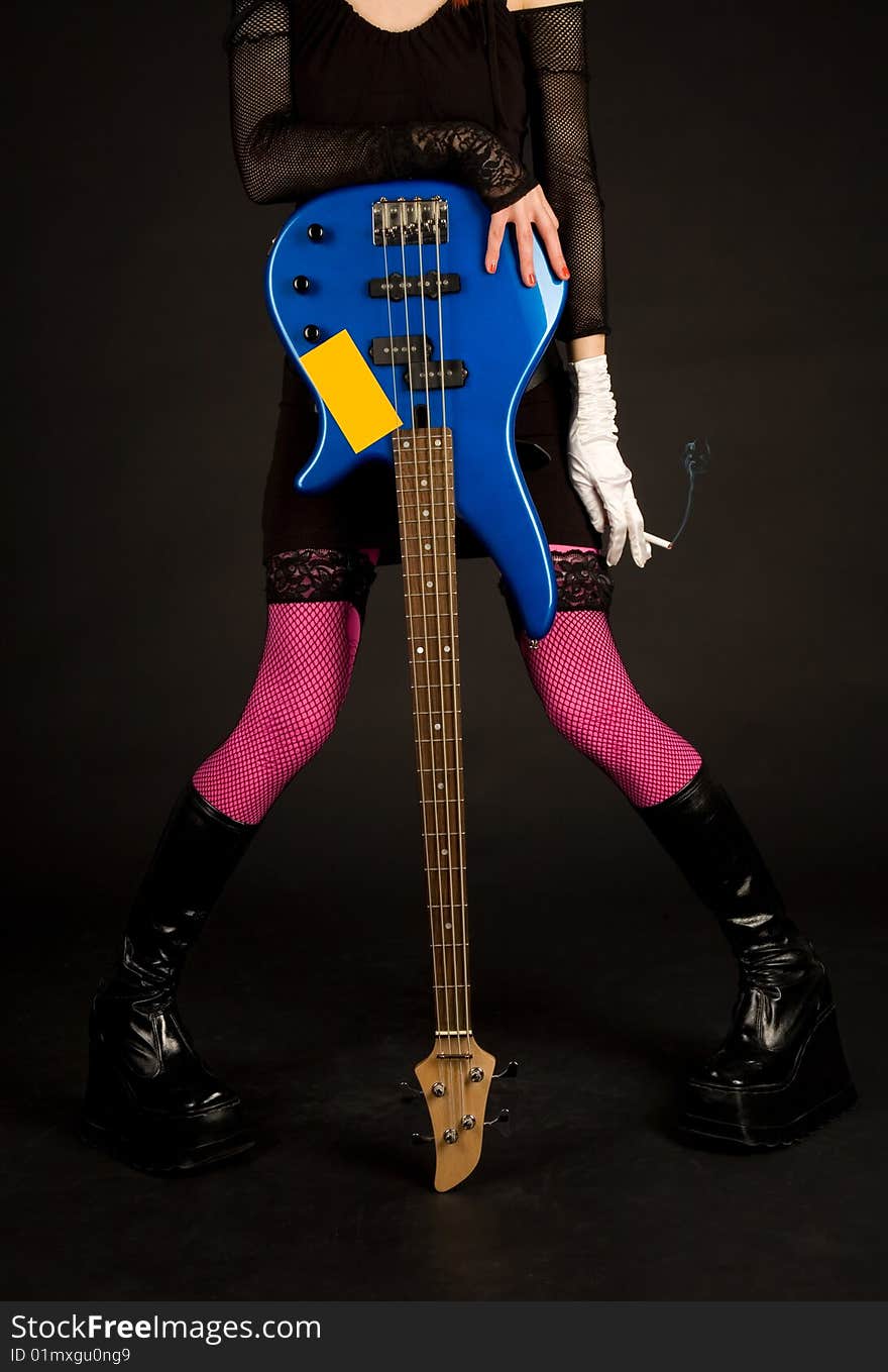 Close-up of girl with bass guitar and cigarette, studio shot