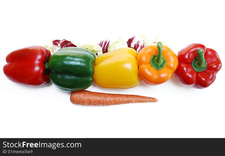 Line of colorful bell peppers surrounded by arugala, carrot. Line of colorful bell peppers surrounded by arugala, carrot