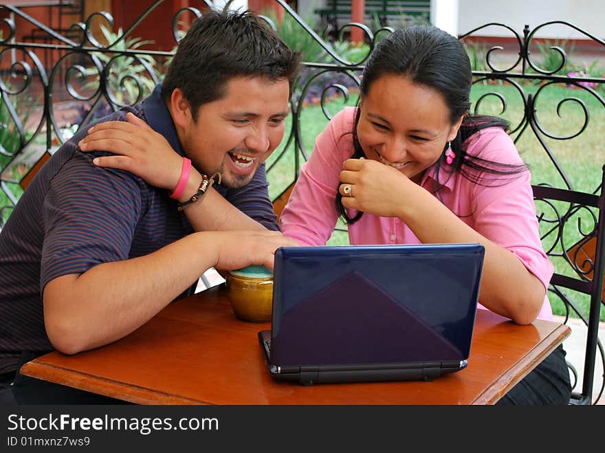 A cute, young HIspanic couple together at a cafe.