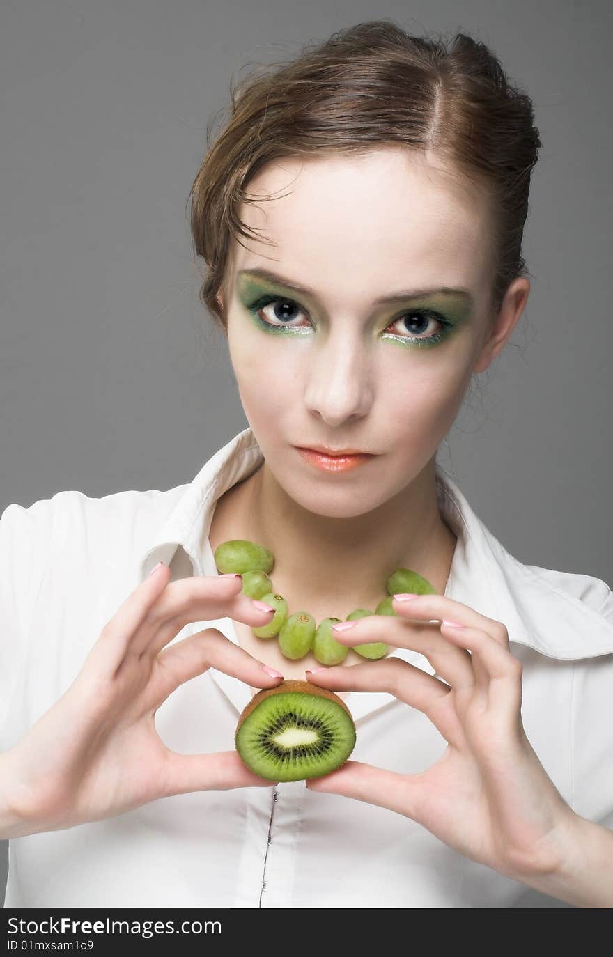 Portrait of young woman with pieces of kiwi. Portrait of young woman with pieces of kiwi