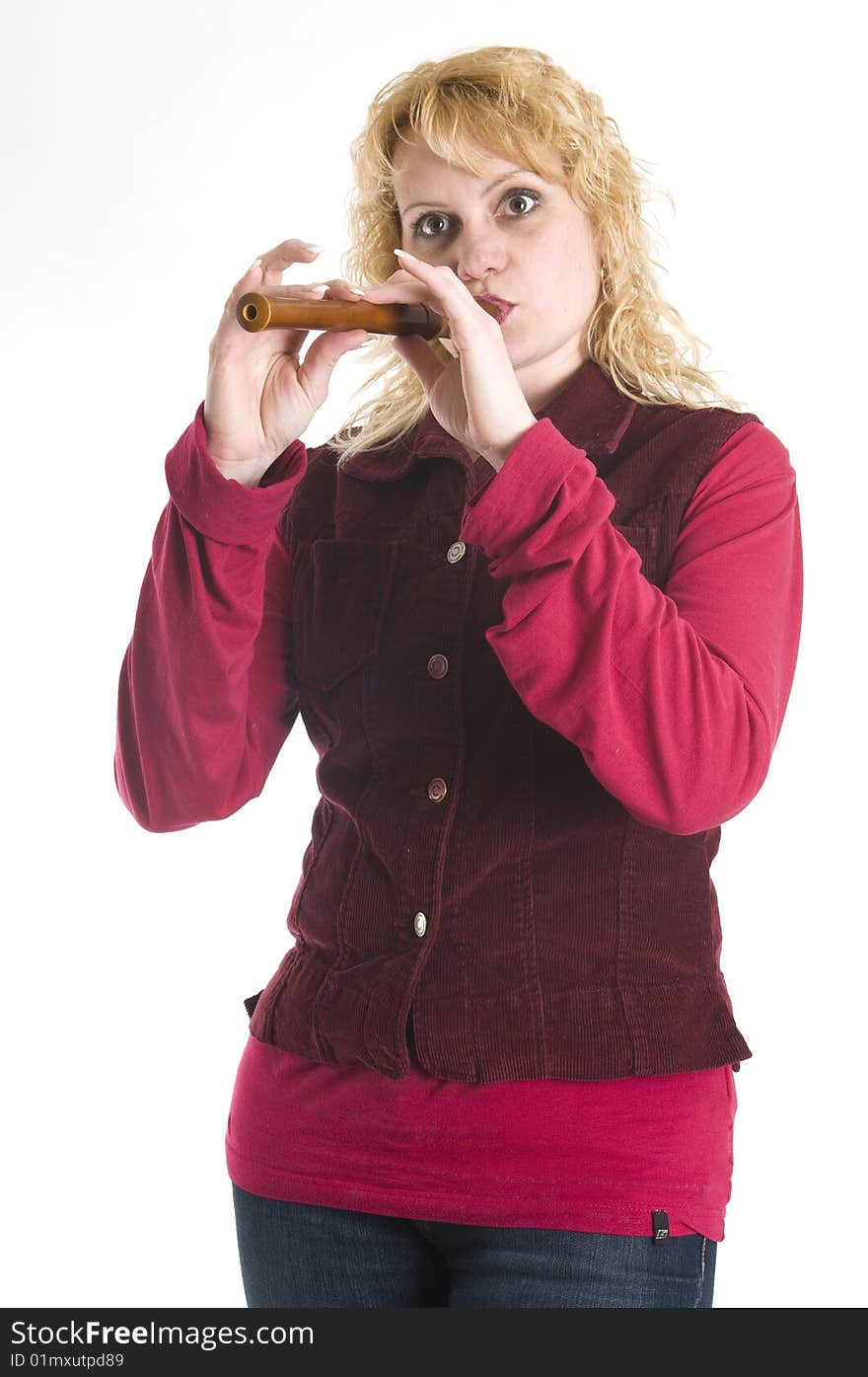 Young beautiful woman in a red shirt plays the flute. Young beautiful woman in a red shirt plays the flute