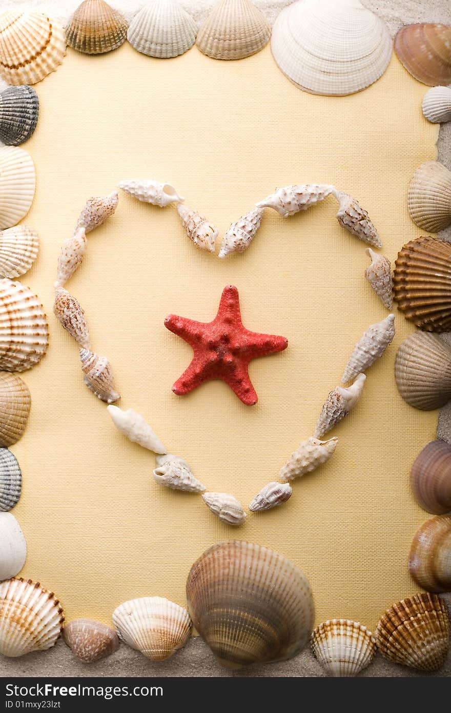 A beautiful yellow letter with shells on sand. A beautiful yellow letter with shells on sand