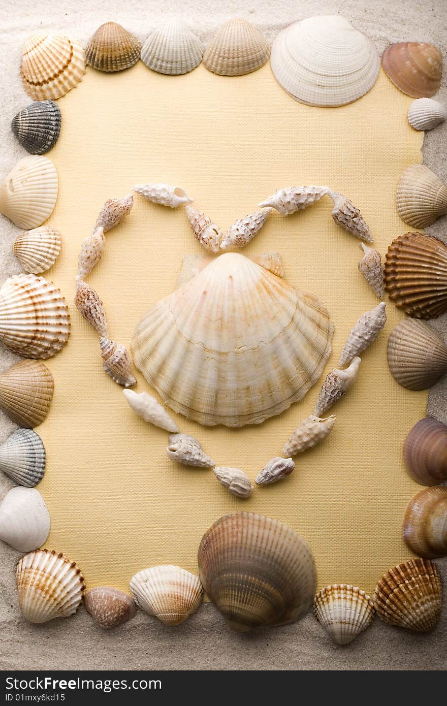 A beautiful yellow letter with shells on sand. A beautiful yellow letter with shells on sand