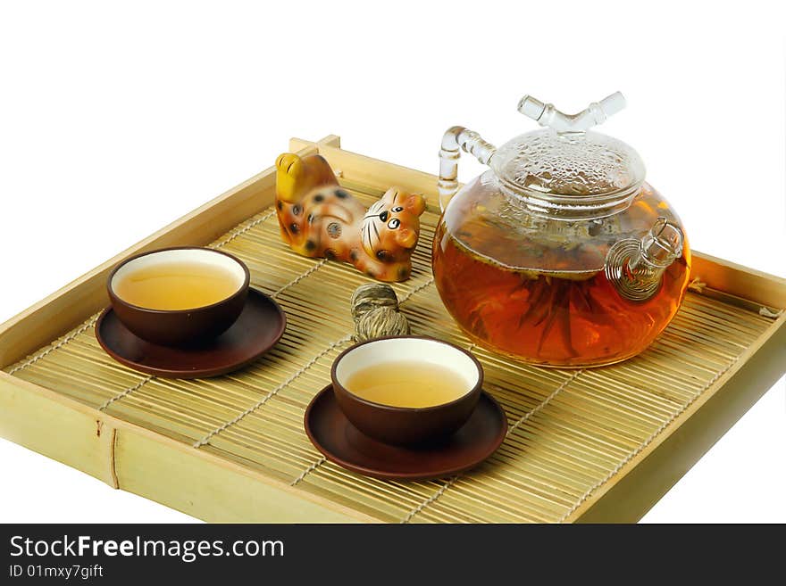 Tea serving in ceramic cups and glass teapot on wooden tray. Isolated on white. Tea serving in ceramic cups and glass teapot on wooden tray. Isolated on white.