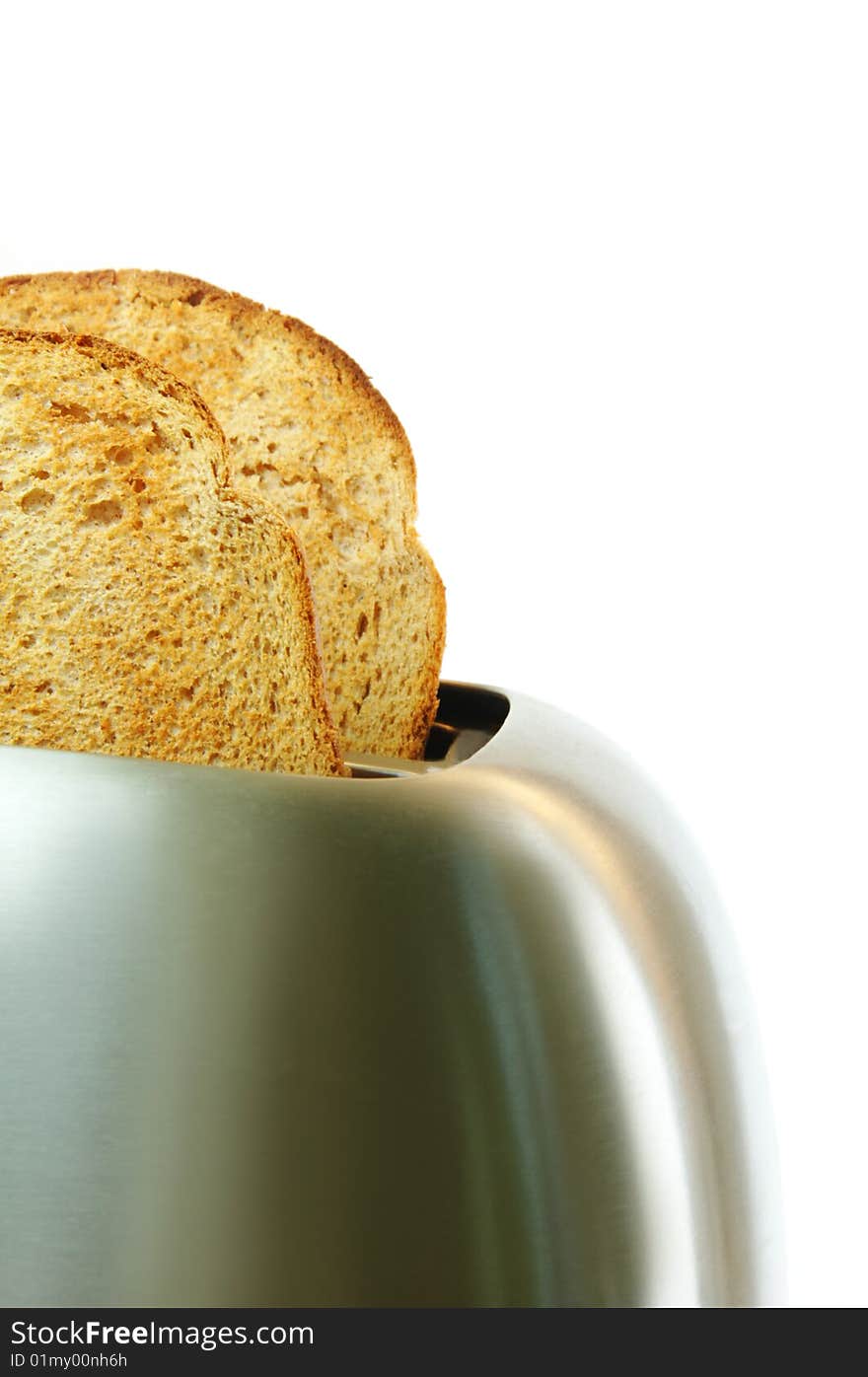 Toasted bread in a stainless steel toaster with a white background. Toasted bread in a stainless steel toaster with a white background.