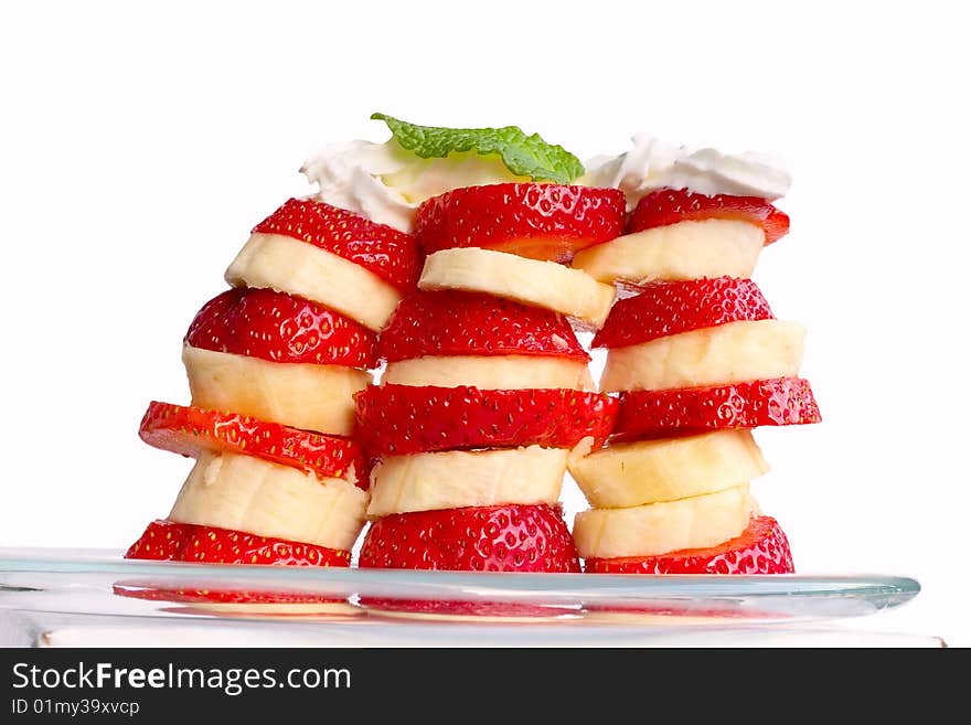 Slices of banana and strawberry, topped with whipping cream. Isolated on white. Slices of banana and strawberry, topped with whipping cream. Isolated on white