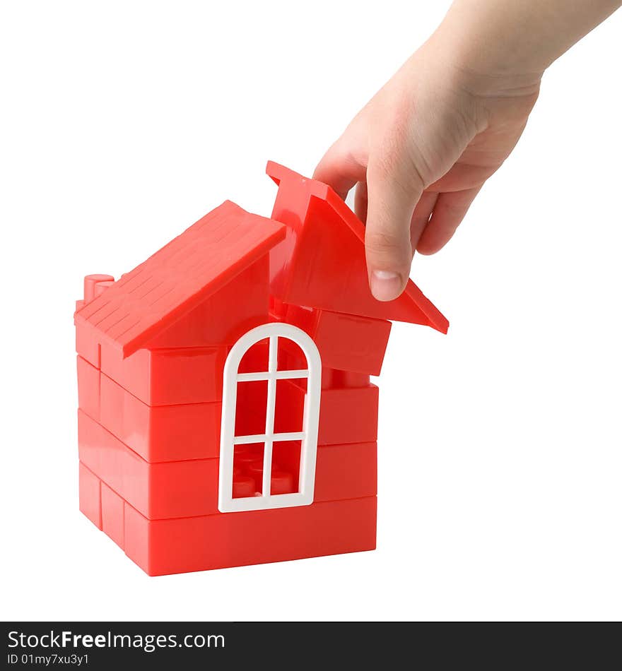 A child's hand holding a doll house made of plastic details for designing on a white background. A child's hand holding a doll house made of plastic details for designing on a white background