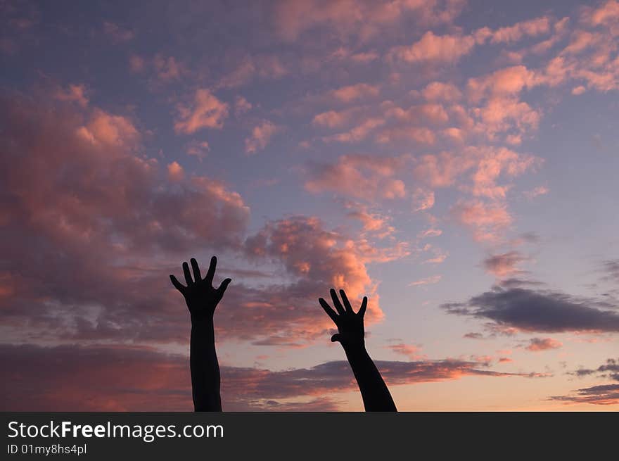 Silhouettes of two women's hands at sunset