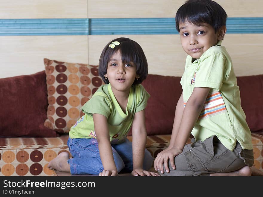 Siblings sitting in front of each other at home. Siblings sitting in front of each other at home