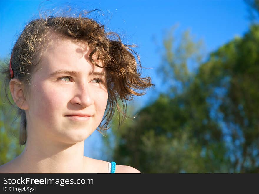 A young white girl with blond hair in the wind looks