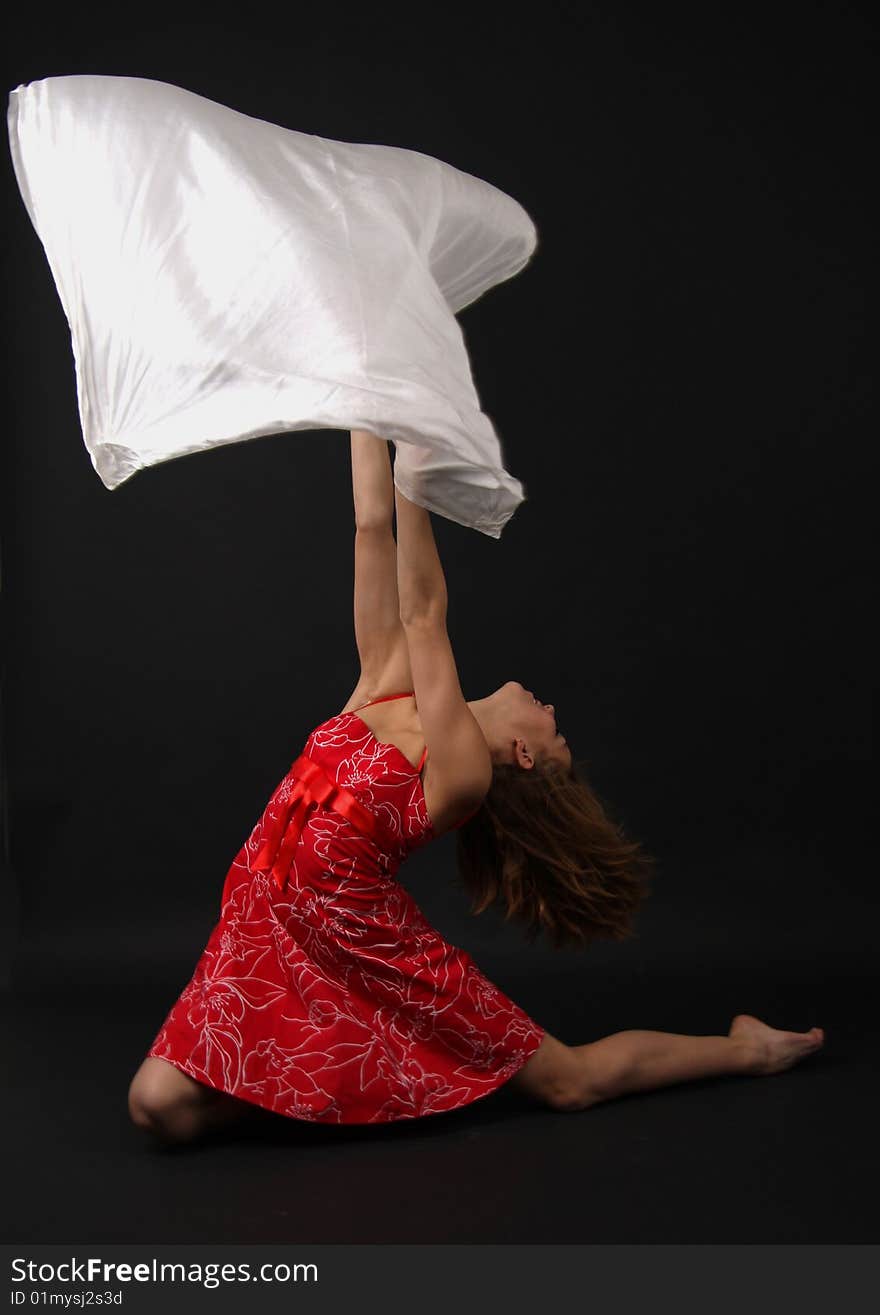 Elegant young flexible woman in red-white outfit with a big scarf