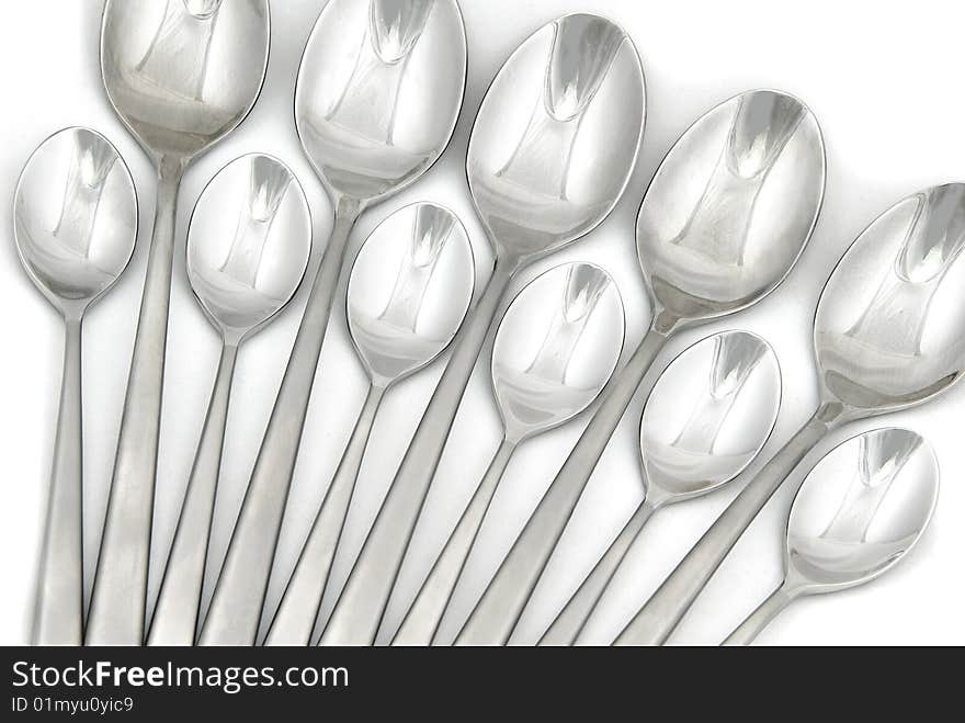 Metallic spoons on white background