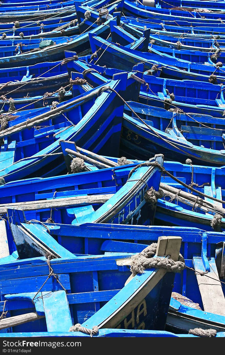 Close-up of many blue fishing boats in bright sunlight. Close-up of many blue fishing boats in bright sunlight