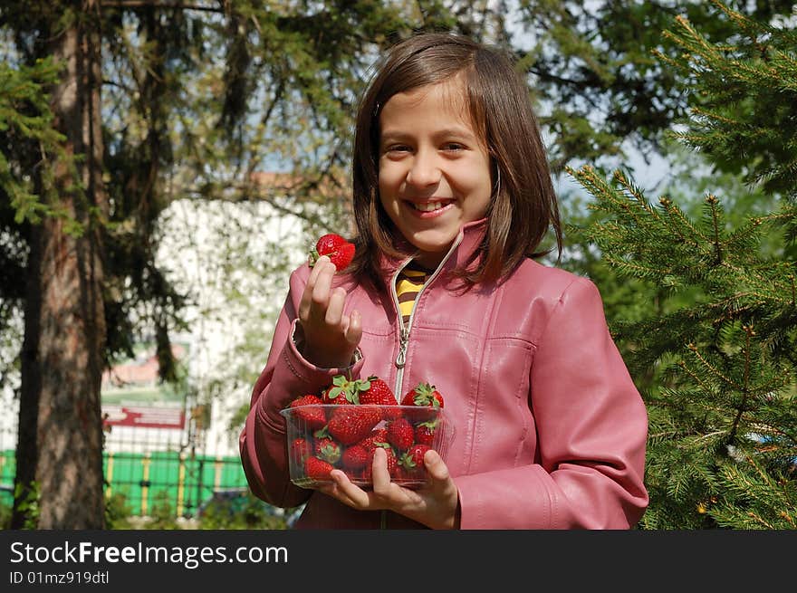 Happy young girl holding strawberries. Happy young girl holding strawberries.