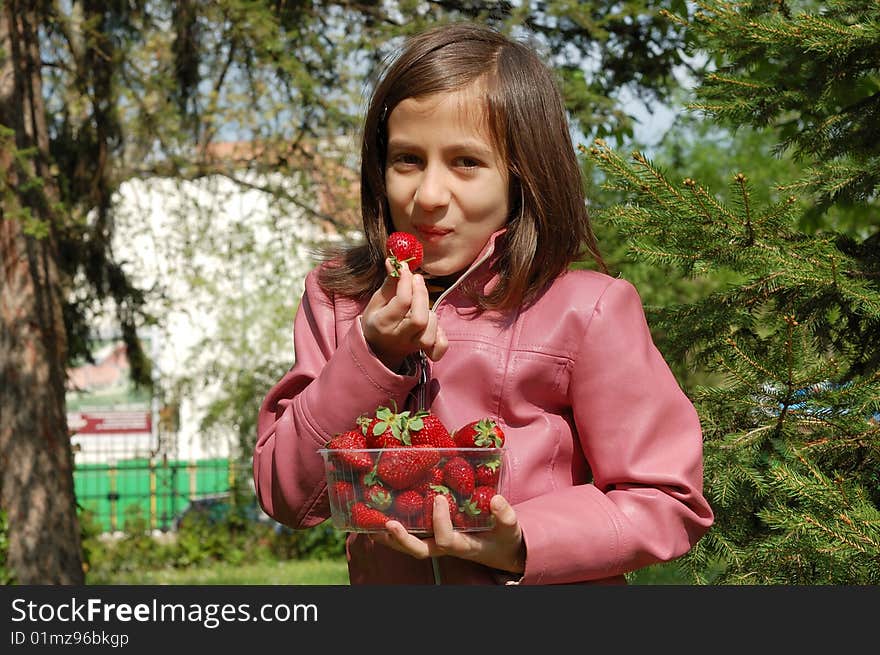 Happy young girl holding strawberries. Happy young girl holding strawberries.