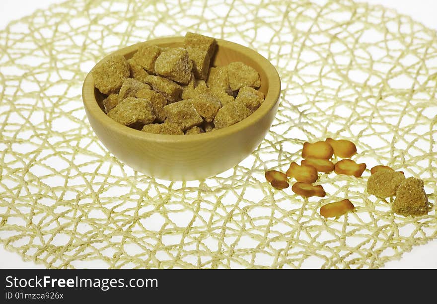 Sugar in wooden plate over table-napkin