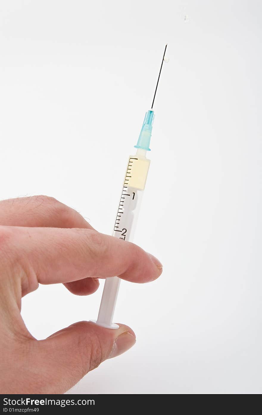 Medical syringe in a hand on a white background