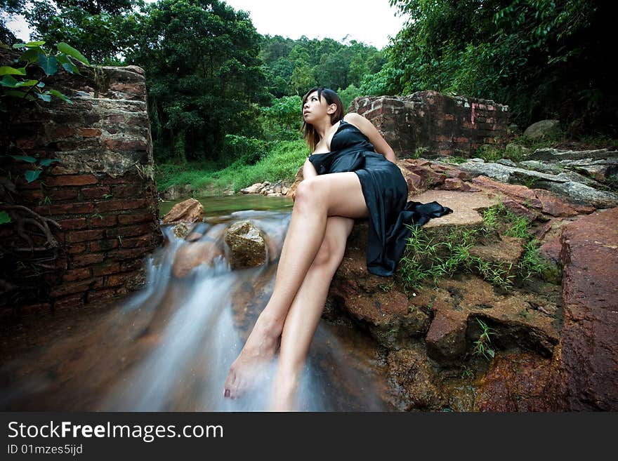 Relaxing Young Woman At Waterfall