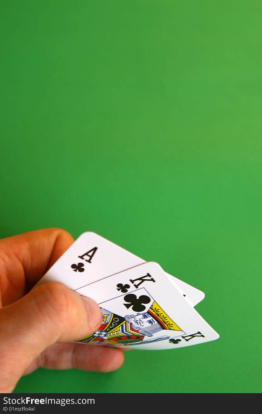 Ace and king clubs in the hand on green background ...