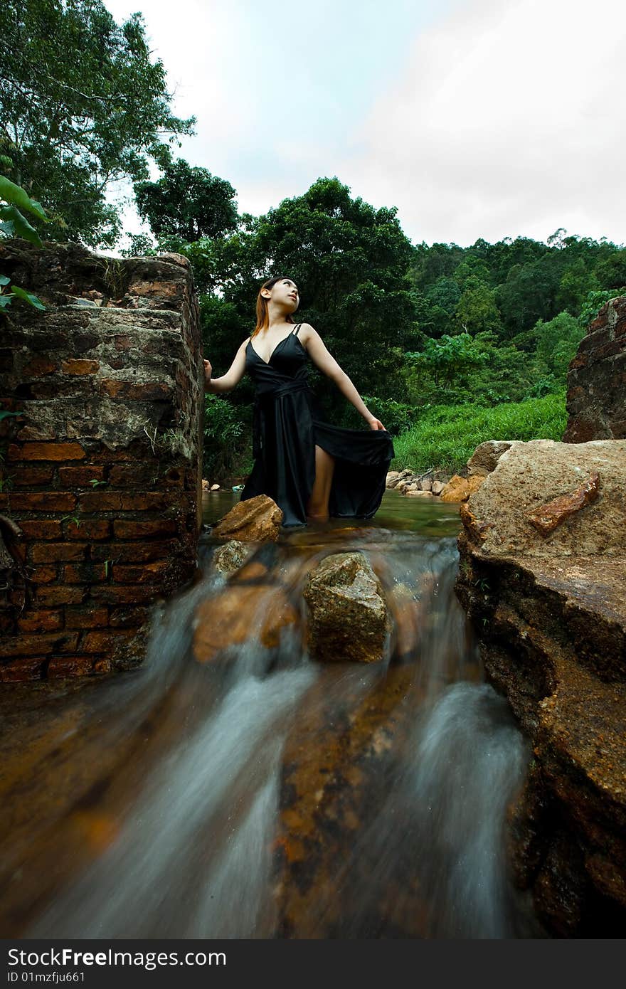 Young woman relaxing outdoor at the tropical waterfall. Young woman relaxing outdoor at the tropical waterfall