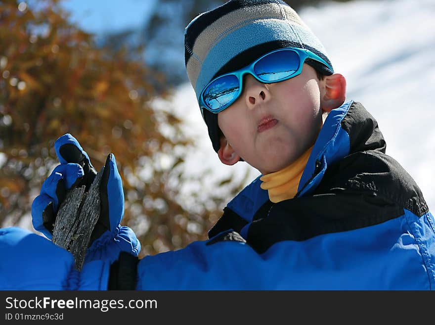 Young Boy having Fun in the Snow, climbing trees, pulling faces. Young Boy having Fun in the Snow, climbing trees, pulling faces