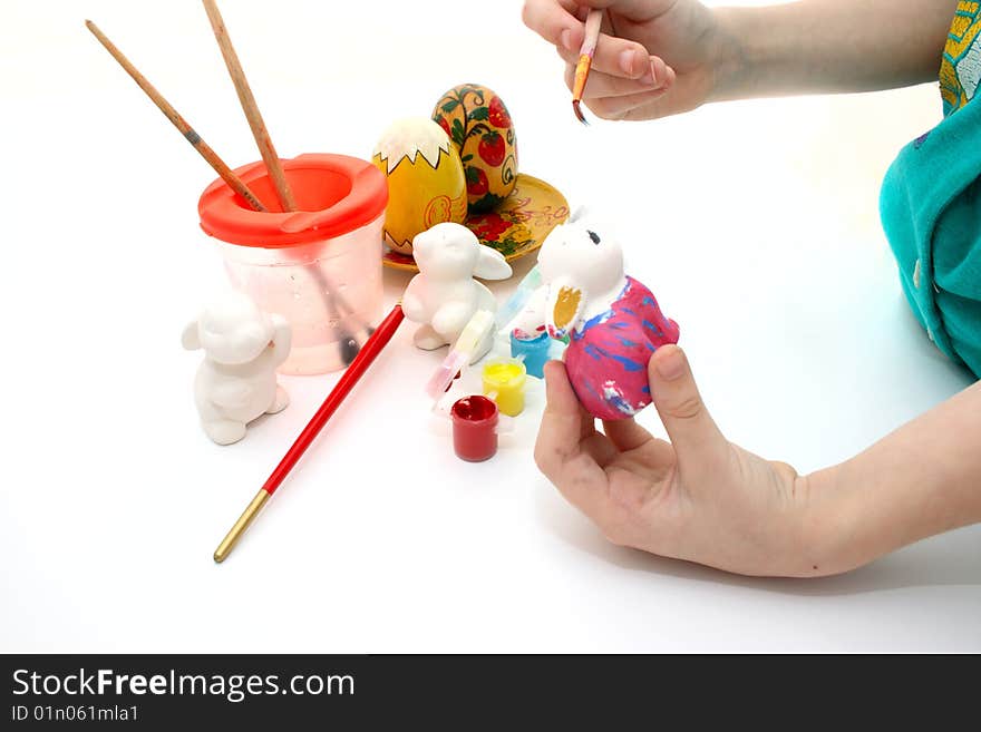 Hands of the child decorate a figure of a rabbit. Hands of the child decorate a figure of a rabbit