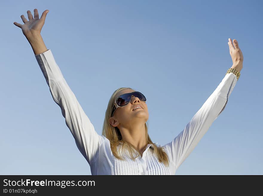 Woman with lifted hands on the background of the sky. Woman with lifted hands on the background of the sky