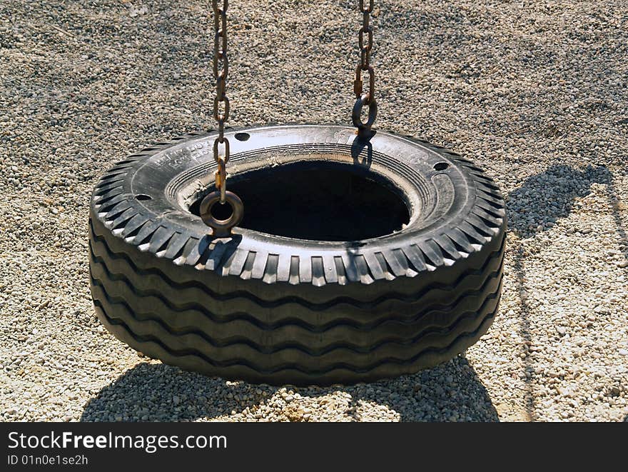 A picture of a tire swing with no children swinging